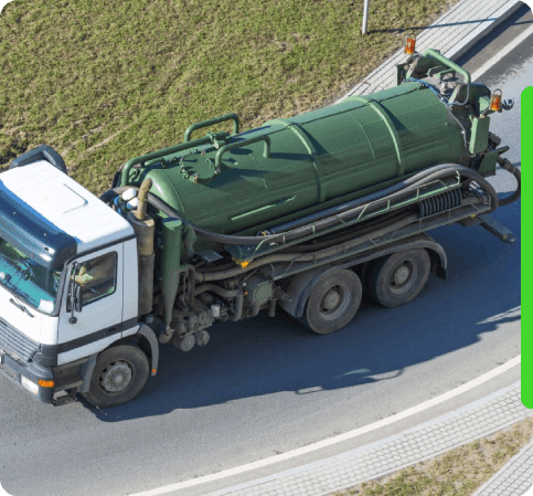 Aerial view of a green sewage vacuum truck driving on a curved road.