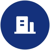 Icon of a tall and a short building in white on a blue circular background.